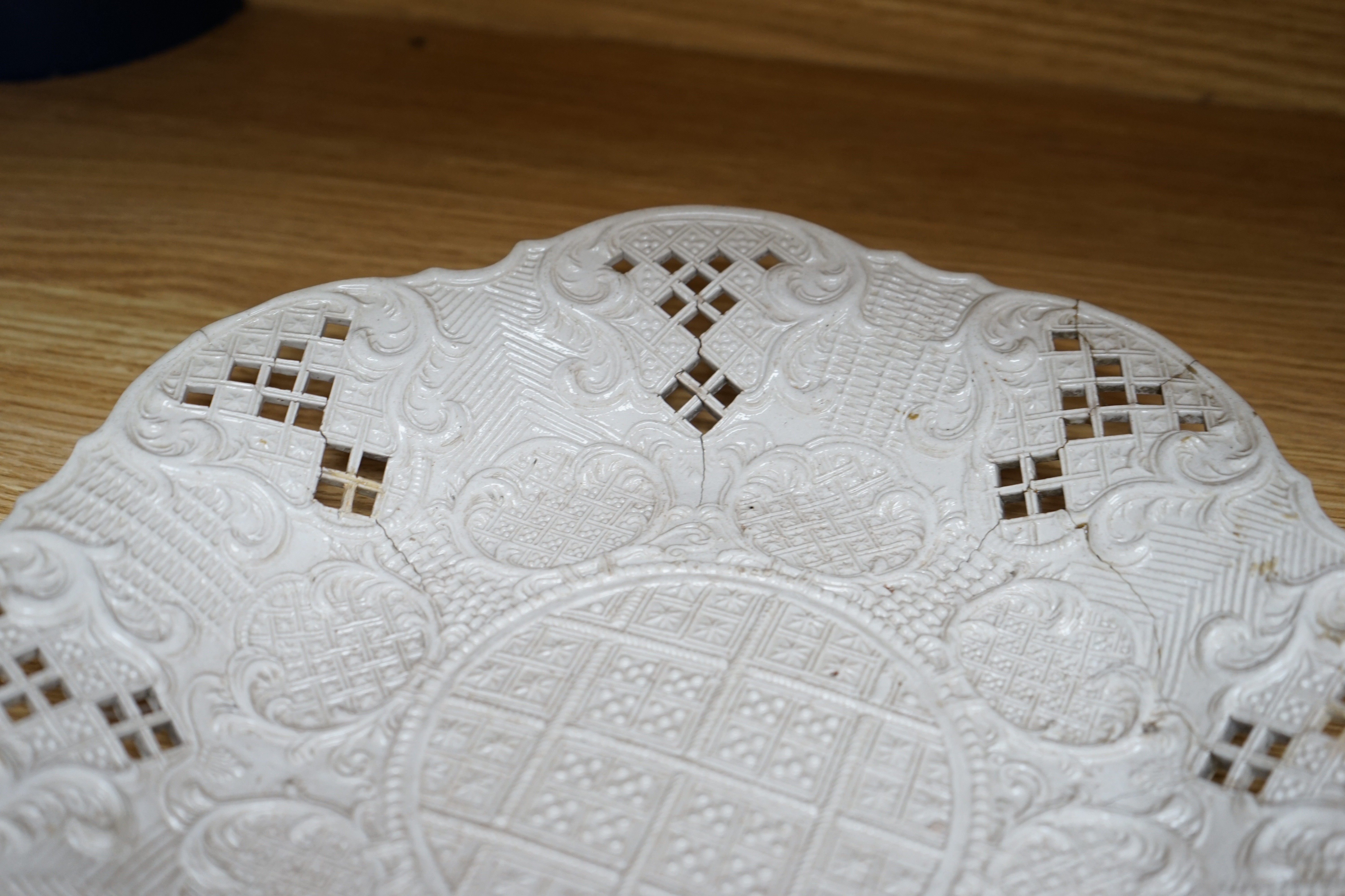 An 18th century white salt-glaze dish, diameter 31cm. (a.f.). Condition - poor, significant cracks and repair